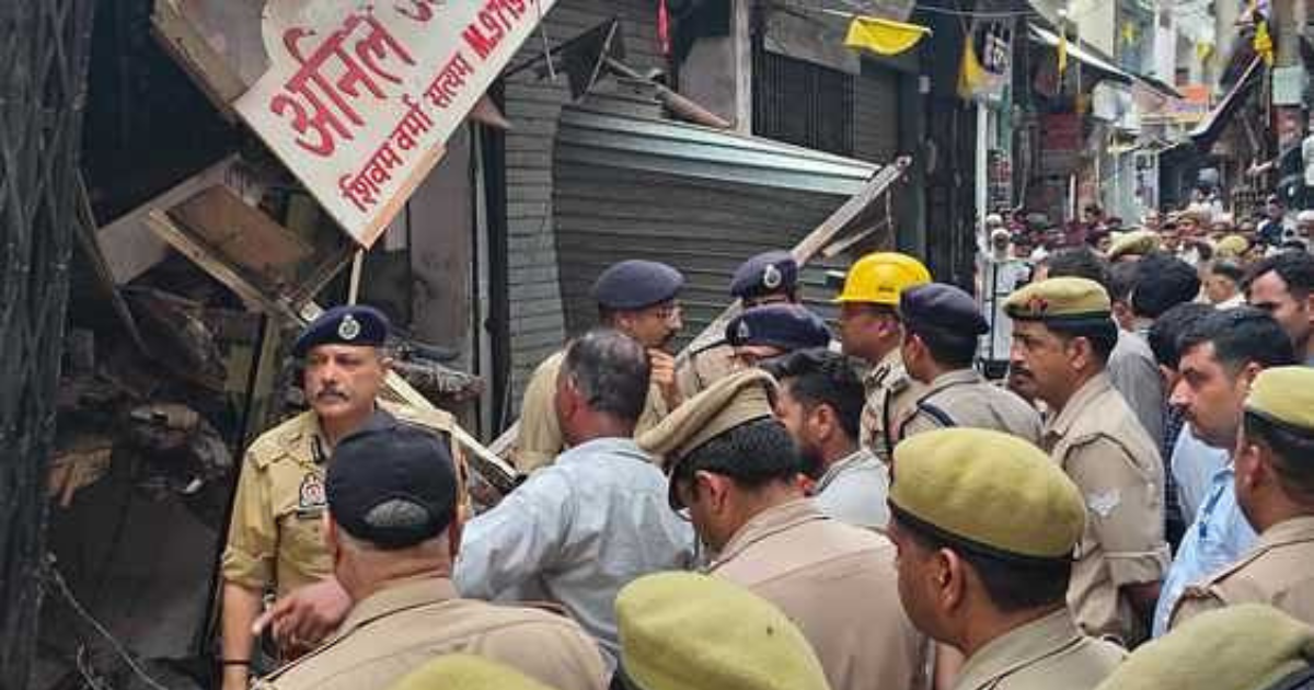 शाहपुर में दुकानें विस्फोट से ध्वस्त, पुलिस अधिकारी मौके पर जांच करते हुए